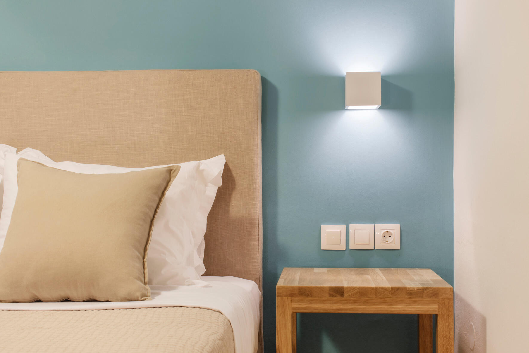 Γωνιά δωματίου boutique ξενοδοχείου με μπλε τοίχο, minimal διακόσμηση και λιτές γραμμές σε φυσικούς τόνους. Boutique hotel room corner with a blue wall, minimalist decor, and clean lines in natural hues. Ask ChatGPT