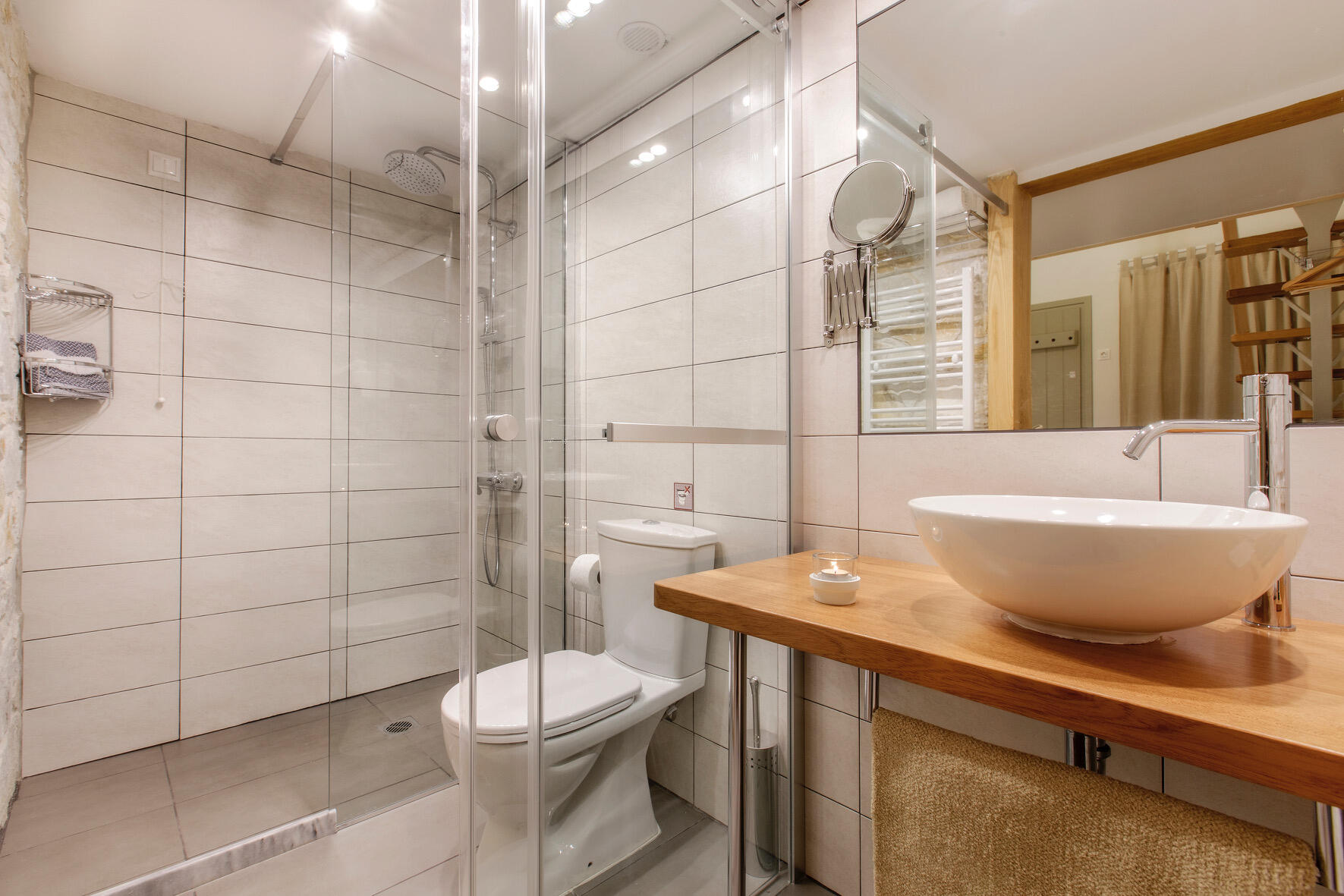 Μοντέρνο μπάνιο με γυάλινη καμπίνα ντους, διαχωριστική γυάλινη πόρτα για την τουαλέτα και εξωτερικό νιπτήρα, σε φωτεινό και καθαρό σχεδιασμό. Modern bathroom with glass shower enclosure, frosted glass partition for the toilet, and an external sink, all in